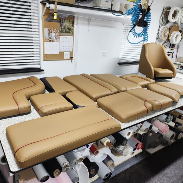 Reupholstery interior axis boat 2016 23' featuring tan and brown premium marine vinyl with red floor accents and custom speakers.