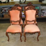 Reupholstery vintage Italian dining chair featuring four hand-carved wooden frames with peach velvet fabric in a professional shop