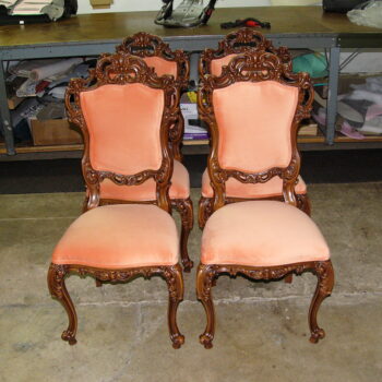 Reupholstery vintage Italian dining chair featuring four hand-carved wooden frames with peach velvet fabric in a professional shop
