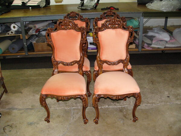 Reupholstery vintage Italian dining chair featuring four hand-carved wooden frames with peach velvet fabric in a professional shop