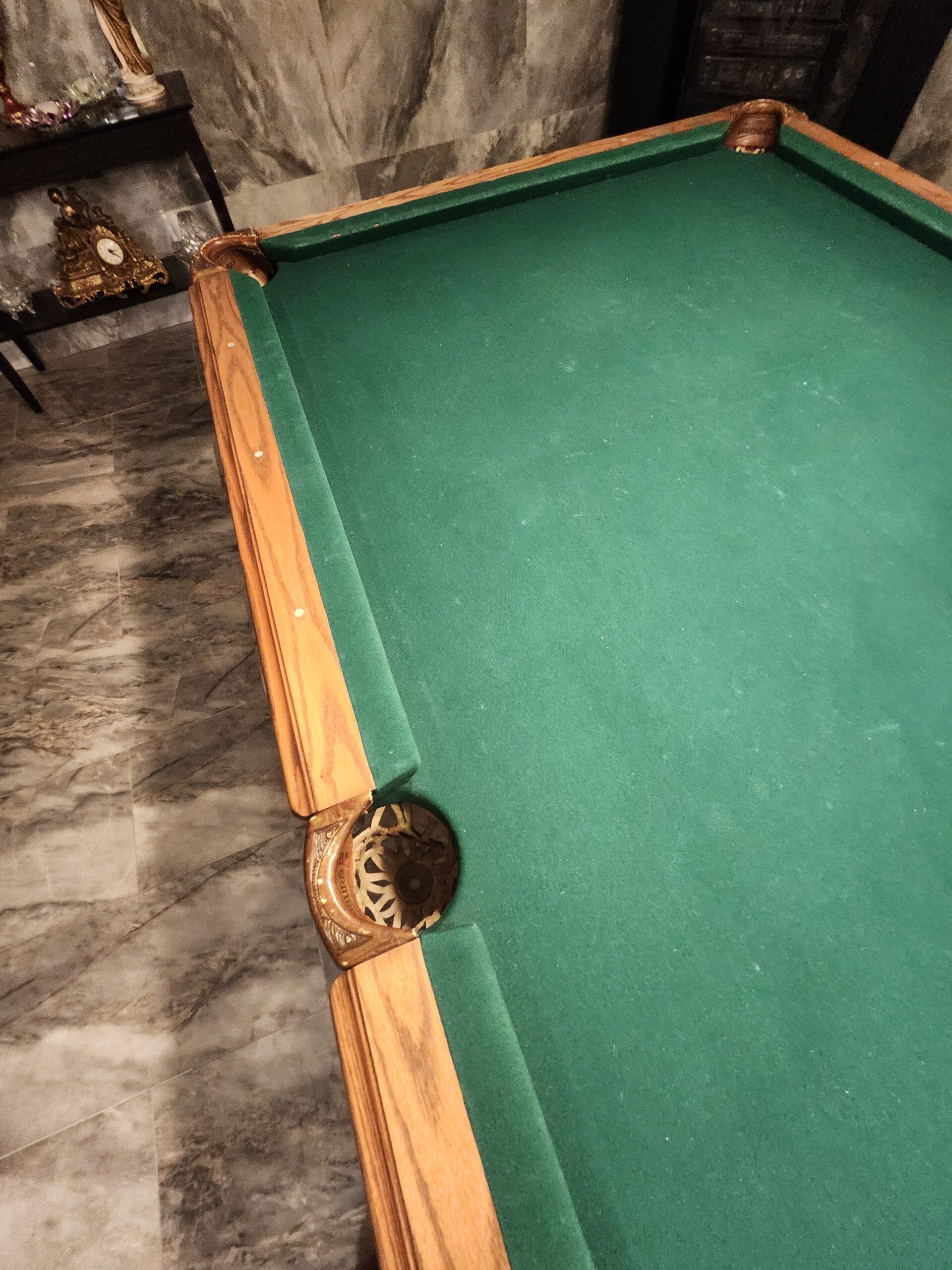 Finished pool table detail after refelting: corner pocket, oak rails with inlaid sights, and smooth tournament green cloth