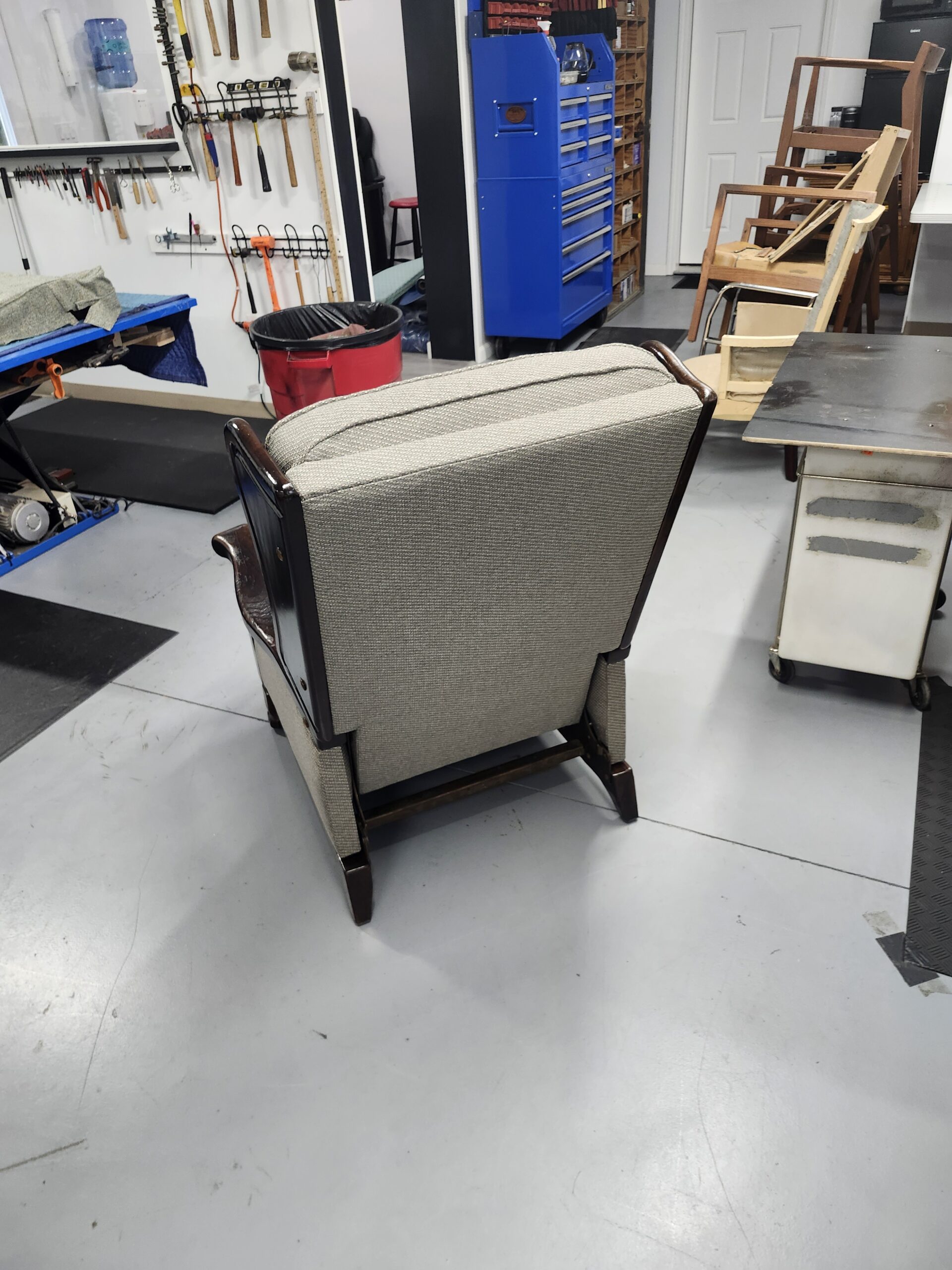Rear view of the finished vintage recliner showing the outside back panel in taupe tweed and the refinished wood base