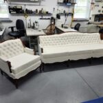 Sofa reupholstery Hershey PA project: French Provincial sofa and matching chair reupholstered in ivory textured fabric with diamond button tufted backs, welted loose cushions and refinished red-brown carved wood trim at Alex Upholstery Shop
