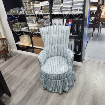 Chair reupholstery Lititz PA project: mid-century round slipper chair reupholstered in a light blue and white dotted stripe fabric with a five button tufted back, round welted seat and gathered skirt, in the Alex Upholstery Shop fabric showroom